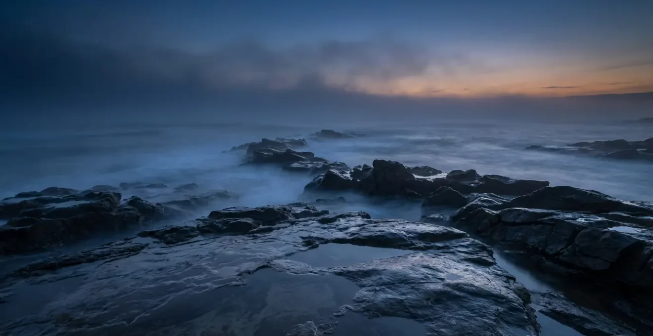 Misty coastline at twilight showing the boundary between worlds
