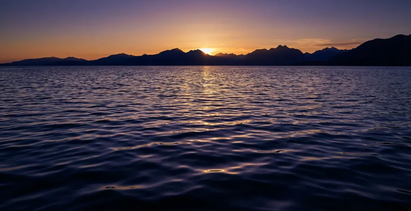 Deep water surface reflecting transformative light patterns representing Scorpio's emotional depth